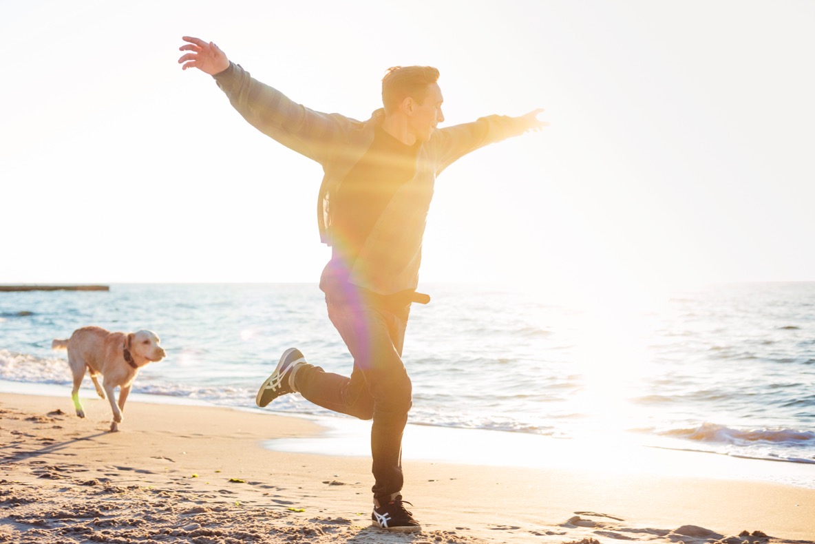 man and dog running sunset