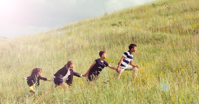 kids going up hill holding hands